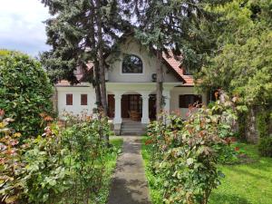 a white house with trees and flowers at Katerina Vendégház in Tihany +24 photos