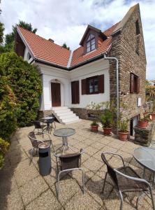 a patio with tables and chairs in front of a building at Katerina Vendégház in Tihany