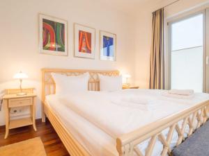 a bedroom with a large white bed and a window at Appartementhaus Sonnenbad - Luxuspenthouse App. 11 in Sassnitz