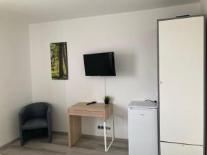ザルツギッターにあるZimmervermietung38- Kranichのデスク、壁掛けテレビが備わる客室です。