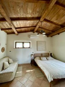 1 dormitorio con 1 cama grande y 1 sofá en Val D’Orcia Eco Cottage, en Campiglia dʼOrcia