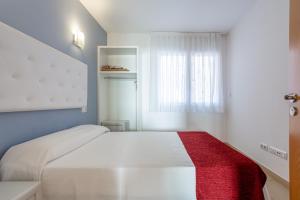 a bedroom with a white bed with a red blanket at S23 Sa Caleta in Lloret de Mar +12 photos