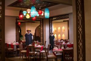 two people standing in a dining room with tables at Sunrise Arabian Beach Resort in Sharm El Sheikh