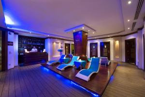 a lobby with blue and white chairs and a bar at Sunrise Arabian Beach Resort in Sharm El Sheikh