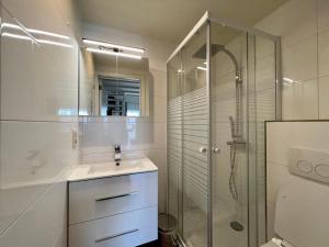 ein weißes Badezimmer mit Waschbecken und Dusche in der Unterkunft Melroce Holiday Cottage 5502 in Bredene + 4 Fotos