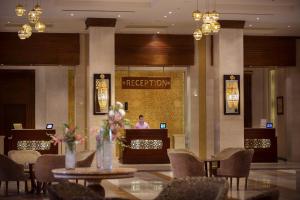 a lobby with tables and chairs and a person in a reception at Sunrise Arabian Beach Resort in Sharm El Sheikh