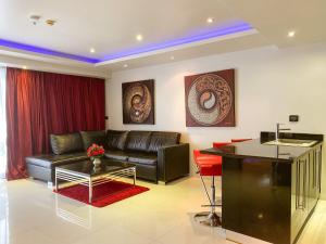 a living room with a leather couch and a table at Absolute Bangla Suites in Patong Beach