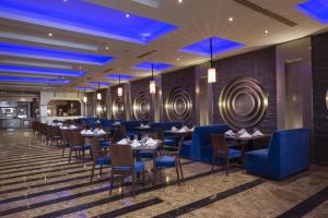 a dining room with tables and chairs and blue lighting at Sunrise Arabian Beach Resort in Sharm El Sheikh