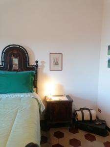 een slaapkamer met een bed en een tafel met een lamp bij Residenza Le Ortensie in Todi