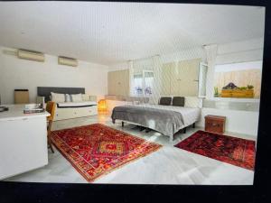 a bedroom with a bed and a couch and two rugs at CASA PALACIO en Jerez de la Frontera con piscina privada in Jerez de la Frontera