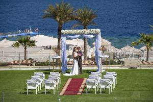a bride and groom are standing under a gazebo at Sunrise Arabian Beach Resort in Sharm El Sheikh