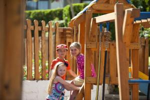 a group of three children sitting on a playground at Sunrise Arabian Beach Resort in Sharm El Sheikh