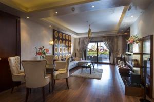a living room with a couch and a table and chairs at Sunrise Arabian Beach Resort in Sharm El Sheikh