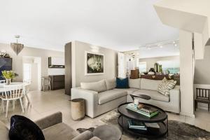 a living room with a couch and a table at Kleinbaai Cottage on the Sea in Cape Town