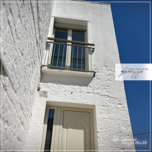 Edificio blanco con ventana y balcón en DIMORE Fanizza, en Alberobello