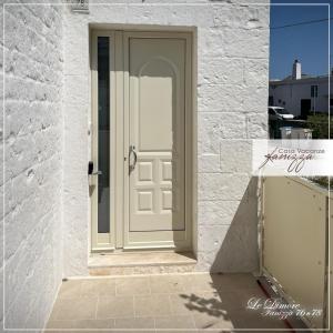 eine weiße Tür in einem weißen Backsteingebäude in der Unterkunft DIMORE Fanizza in Alberobello