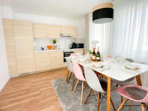 a dining room with a white table and pink chairs at M-Style 02 Apartment mit Balkon 24h Self-Check-In, Free Parking, Netflix in Nürnberg