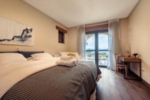 um quarto com uma cama, uma secretária e uma janela em Villa Kalamos / Sea View and Pool nearby Athens em Kalamos