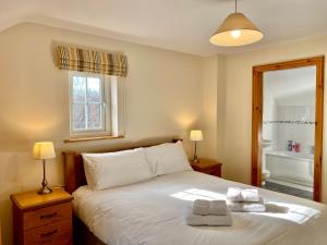 a bedroom with a bed with two towels on it at Shamrock Cottage in Aghnablaney