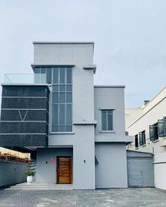 una casa grigia con una porta marrone di De Fivez a Lagos
