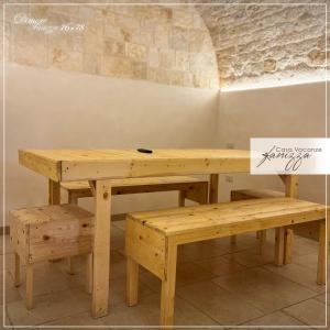 una mesa de madera y un banco junto a una pared en DIMORE Fanizza, en Alberobello