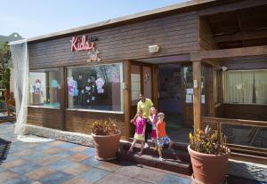 a woman and two children standing in front of a store at Sunrise Arabian Beach Resort in Sharm El Sheikh