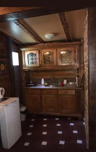 a kitchen with wooden cabinets and a sink at Chalet Etno Oaza near Airport in Sarajevo