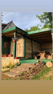 a brick house with a green roof and a patio at Chalet Etno Oaza near Airport in Sarajevo +8 photos