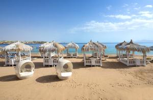 a group of chairs and umbrellas on a beach at Sunrise Arabian Beach Resort in Sharm El Sheikh
