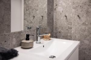 a bathroom sink with a soap dispenser on it at Norra Station Executive Suite - 3km from City Centre in Stockholm