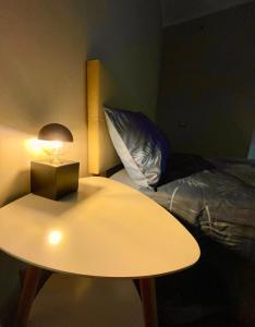 um quarto com uma mesa, uma cama e um candeeiro em Perugia Home Apartment Pinturicchio em Perugia