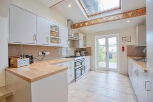 a large kitchen with white cabinets and a skylight at 5 Bedroom Family Retreat Exmouth, Devon in Exmouth