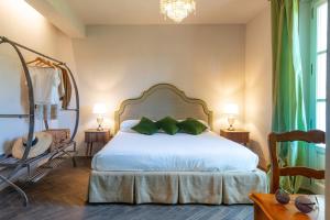 a bedroom with a white bed with green pillows at Agriturismo Villa Toscana in Campiglia Marittima