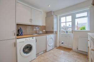 a kitchen with a washing machine and a window at 5 Bedroom Family Retreat Exmouth, Devon in Exmouth