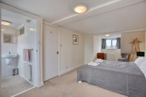 a bedroom with a bed and a bathroom with a sink at 5 Bedroom Family Retreat Exmouth, Devon in Exmouth