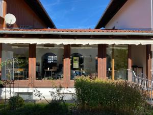 un edificio con grandes ventanas con mesas y sillas en Abendruhe Hotel - kontaktloser Check In, en Oberhaching