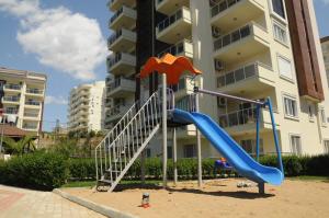 a playground in front of a building with a slide at Orion Valley Home in Avsallar