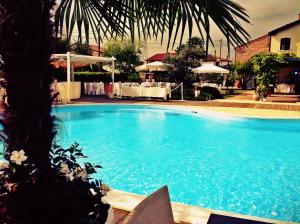 a large blue swimming pool with a table in the background at Do Ciacole In Relais in Mira
