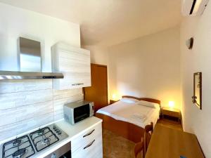 a small room with a bed and a kitchen at Monolocale Italia in Tergu
