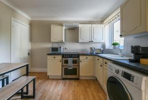 a kitchen with white cabinets and a stove top oven at The Colebrook in Royal Tunbridge Wells