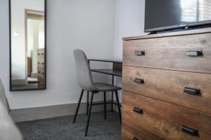 a dresser with a chair sitting next to a mirror at The Colebrook in Royal Tunbridge Wells