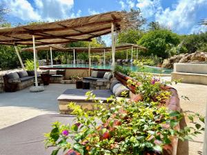 eine Terrasse mit einem Pool und einem Pavillon mit Pflanzen in der Unterkunft Rock and Sea Resort in Watamu