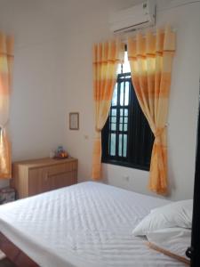 1 dormitorio con cama blanca y ventana en Cuc Phuong Hao Tham Homestay Hotel, en Phủ Nho Quan