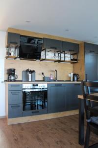 a kitchen with blue cabinets and a stove at Hausboot Wangermeer Nordsonne11 in Wangerland