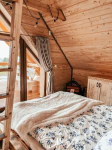 a bedroom with a bed in a wooden cabin at Wood Szczęścia in Korczyna