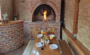 a brick oven with a table and a fireplace at Holiday&wellness house Grofica in Daruvar