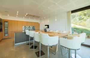 a kitchen and dining room with a table and white chairs at Villa Marvelo in El Port