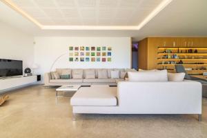 a living room with a white couch and a tv at Villa Marvelo in El Port