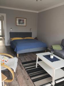 een slaapkamer met een bed, een tafel en een bank bij Appartementhaus Martel - Adults Only in Travemünde