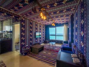 a living room with a wall covered in colorful wallpaper at Downtown Sea View Suites in Alexandria